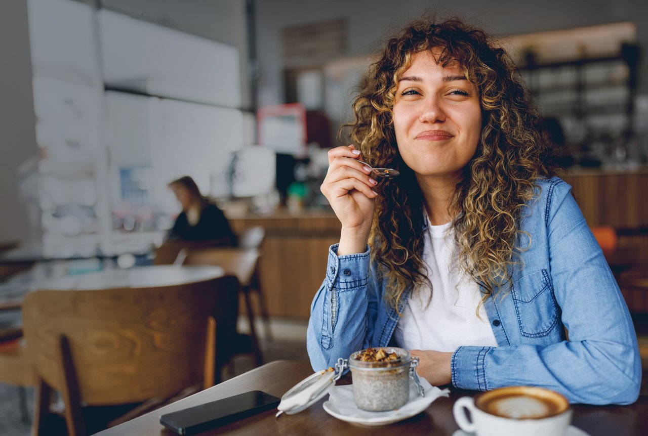 Woman in cafe enjoying a plant-based breakfast